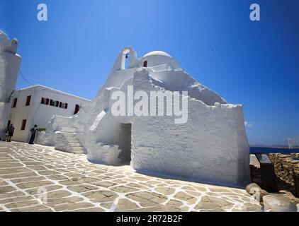 Belle vieille église fortifiée en pierre blanche et lumineuse, contre un ciel bleu pâle brillant - Mykonos, Grèce Banque D'Images