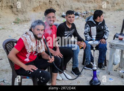 Gaza, Palestine. 11th juin 2023. Des jeunes Palestiniens fument des chicha sur la plage de Deir El Balah, dans le centre de la bande de Gaza. Crédit : SOPA Images Limited/Alamy Live News Banque D'Images