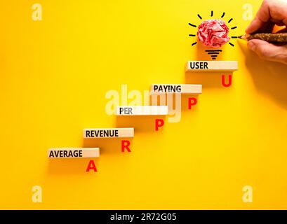 Revenu moyen ARPPU par symbole d'utilisateur payeur. Mots de concept ARPPU revenu moyen par utilisateur payant sur bloc de bois. Magnifique fond jaune. Entreprise Banque D'Images