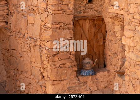 Une vieille boîte de thé devant une ancienne fenêtre d'une maison berbère au Maroc Banque D'Images