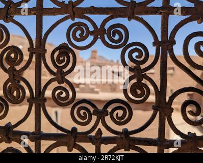 Grille de fenêtre traditionnelle ornée d'une maison berbère en ruine dans le centre-ville d'Amezrou, Maroc Banque D'Images