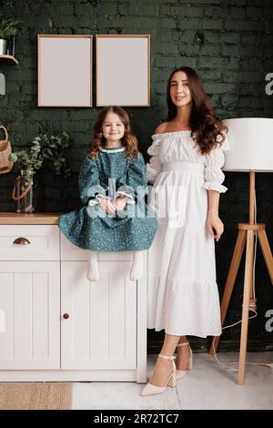 Fête des mères. Une jeune maman sensible embrasse sa petite fille adorable à la maison. Confiance, soutien et amour entre maman et enfant. Une famille aimante Banque D'Images