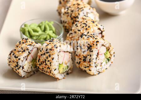 Ensemble de délicieux petits pains à sushis et wasabi sur l'assiette, en gros plan Banque D'Images