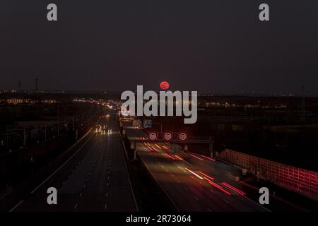 Image de la lune rose qui s'élève au-dessus d'une autoroute allemande en avril 2021 dans la soirée Banque D'Images