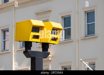 Vue à angle bas de deux radars de vitesse jaune vif sur un arrière-plan urbain. Banque D'Images