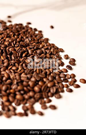 Déversement de grain de café sur le comptoir de marbre, image de café moderne, grains de café, image de stock de café, marque de café, marque de café, grain de café torréfié foncé Banque D'Images