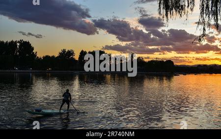 (230613) -- BEIJING, 13 juin 2023 (Xinhua) -- cette photo prise sur 10 juin 2023 montre le lac Shichahai au coucher du soleil dans le centre de Pékin, capitale de la Chine. Créé pour la première fois dans la dynastie Yuan (1271-1368), l'axe central de Beijing, ou Zhongzhouxian, s'étend sur 7,8 kilomètres entre la porte de Yongding (Yongdingmen) au sud de la ville et la Tour du tambour et la Tour de la cloche au nord. La plupart des grands bâtiments de la vieille ville de Beijing s'assoient le long de cet axe.quatorze endroits historiques le long de l'axe, y compris Qianmen, la Cité interdite, le Parc Jingshan, les Tours tambour et Bell, et la place Tian'anmen ont l'abeille Banque D'Images