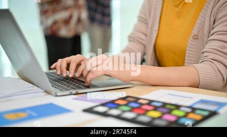 Une image rapprochée d'une graphiste asiatique professionnelle ou d'un développeur UI,UX travaille sur son travail sur son ordinateur portable à son bureau. Banque D'Images