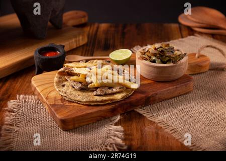 Tacos au bœuf et frites. Taco très populaire au Mexique appelé Taco de Bistec ou Carne Asada, rôti de bœuf fait maison servi sur une tortilla de maïs. Moi Banque D'Images