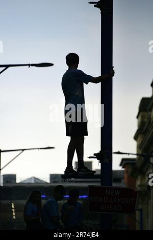 Manchester, Royaume-Uni. 12th juin 2023. Un fan de Man City se tient sur la jambe de force au feu de la rue pour assister à la parade de la victoire en bus à toit ouvert dans le centre de Manchester, au Royaume-Uni, pour marquer la réussite de leur club gagnant les aigus : la Premier League, la FA Cup et la Champions League. Samedi, Man City a battu Inter Milan à Istanbul pour obtenir la victoire de la Ligue des Champions. La parade des bus à toit ouvert a traversé le centre-ville de Manchester et a été suivie par de grandes foules enthousiastes, malgré un orage et de fortes pluies. Crédit : Terry Waller/Alay Live News Banque D'Images