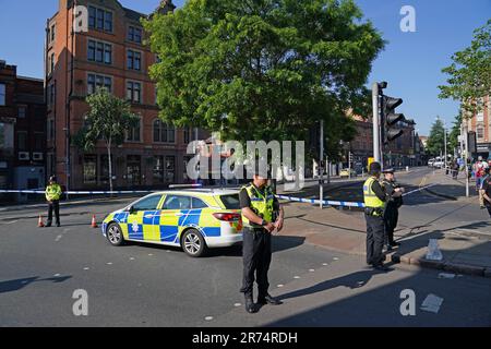 Des policiers au carrefour Maid Marian Way de la rue Upper Parliament à Nottingham, comme la police a mis en place plusieurs fermetures de routes à Nottingham, car les policiers sont confrontés à un incident grave en cours. Le réseau de tramway de Nottingham Express Transit (NET) a déclaré avoir suspendu tous les services en raison d'incidents de la police dans la ville et la banlieue. Date de la photo: Mardi 13 juin 2023. Banque D'Images