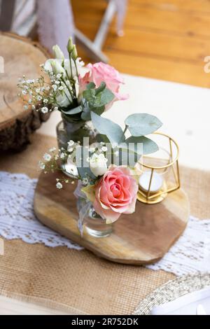 Deux petits bouquets de fleurs sur une planche en bois comme décoration de table à une fête Banque D'Images