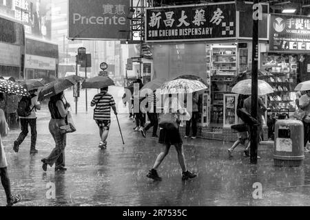 Les gens ordinaires de Hong Kong à l'extérieur et autour pendant Un orage , Causeway Bay, Hong Kong, Chine. Banque D'Images