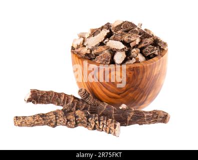 Racine de calamus dans un bol en bois, isolée sur fond blanc. Drapeau doux, balancement ou racine de rat musqué. Racine sèche d'Acorus calamus. Banque D'Images