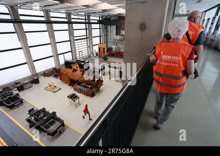 Wernigerode, Allemagne. 13th juin 2023. Un groupe de visiteurs portant des gilets haute visibilité et des casques de sécurité se tient au cours d'une visite guidée du nouvel atelier du Harzer Schmalsurbahnen HSB à Wernigerode. Pour la première visite officielle de l'atelier dans le nouvel atelier de la Harzer Schmalsjappenn GmbH, les visiteurs ont pu voir le nouveau bâtiment moderne, y compris l'atelier. Désormais, des visites guidées seront proposées régulièrement le mardi. Des visites spéciales sont également possibles sur rendez-vous. Credit: Matthias Bein/dpa/Alay Live News Banque D'Images