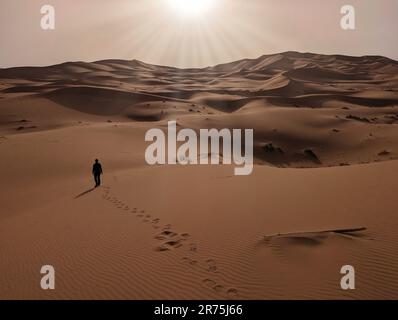 Une personne marchant dans le désert d'Erg Chebbi dans le Sahara africain, désert marocain Banque D'Images