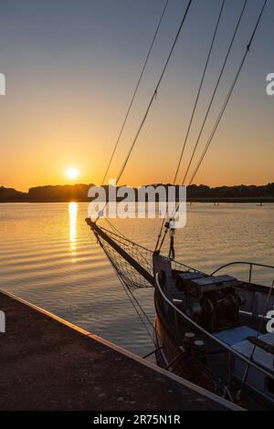 Coucher de soleil sur la rivière Warnow dans le port de la ville hanséatique de Rostock. Banque D'Images