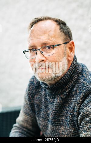 Portrait extérieur d'un homme de 50 ans portant un pull-over et des lunettes marron Banque D'Images