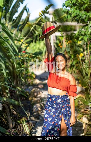 Amérique du Nord, Caraïbes, Grande Antilles, Île d'Hispaniola, République dominicaine, Province de SAMA, Péninsule de Sama, El Limón, Sama Eco Lodge, jolie Latina sur un chemin de gravier ombragé dans le jardin tropical. Banque D'Images