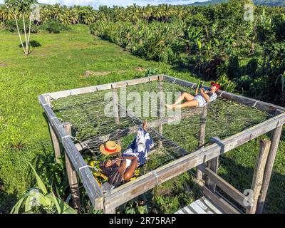 Amérique du Nord, Caraïbes, Grande Antilles, Île d'Hispaniola, République dominicaine, Province de SAMA, Péninsule de Sama, El Limón, de jolies femmes se trouvant sur un énorme hamac dans Sama Eco Lodge Banque D'Images