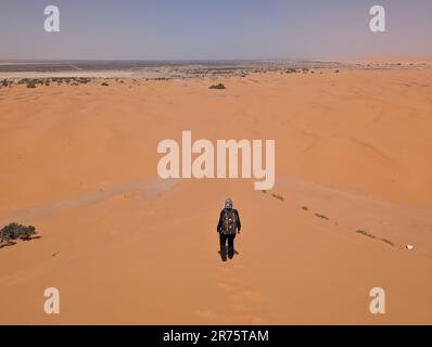 Randonnée dans la grande dune de Merzouga dans le désert d'Erg Chebbi, Sahara marocain Banque D'Images