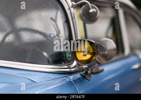 Izmir, Turquie - 3 juin 2023 : gros plan de la lampe de signalisation sur le miroir d'une Chevrolet bleu ciel 1954, décorée de gouttes de pluie Banque D'Images