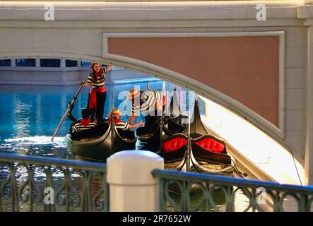 Les employés de gondolier à la fin de la journée sous un pont se déplaçant entre les gondoles dans le faux Grand Canal à la Venetian Las Vegas Nevada USA Banque D'Images