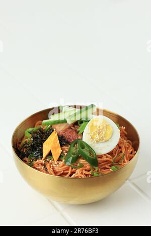 Bibim Guksu Korean Spicy nouilles froides avec divers garnitures. Isolé sur fond blanc Banque D'Images