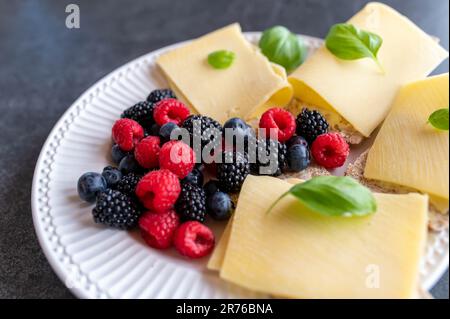 Croque-monsieur à base de carb avec vieux fromage gouda et baies fraîches sur une assiette Banque D'Images