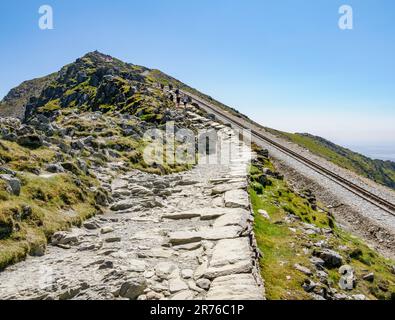 Piste pavée et chemin de fer de Snowdon Mountain partageant la dernière ascension de la crête jusqu'au sommet d'Yr Wyddfa dans le parc national d'Eryri, au nord du pays de Galles du Royaume-Uni Banque D'Images