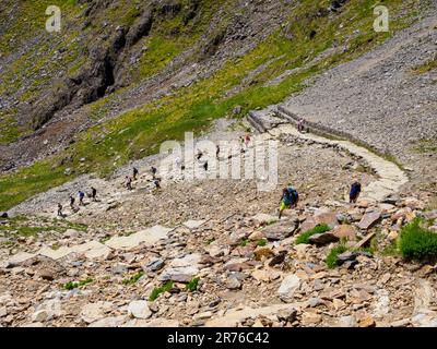 Marcheurs montant et descendant la piste PYG une route populaire vers la crête du sommet de Yr Wyddfa Snowdon dans le parc national de Snowdonia au nord du pays de Galles Banque D'Images