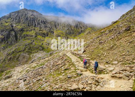 Marcheurs montant de la piste PYG un itinéraire populaire vers la crête du sommet de YR Wyddfa Snowdon dans le parc national de Snowdonia au nord du pays de Galles Banque D'Images