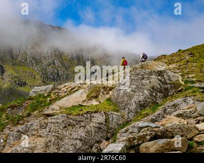 Marcheurs montant de la piste PYG un itinéraire populaire vers la crête du sommet de YR Wyddfa Snowdon dans le parc national de Snowdonia au nord du pays de Galles Banque D'Images