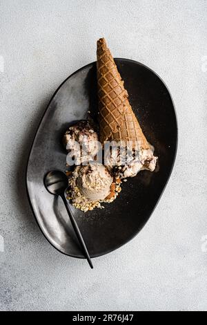 De dessus les cornets de gaufres avec du café et de la glace au chocolat sur l'assiette sur fond de béton Banque D'Images