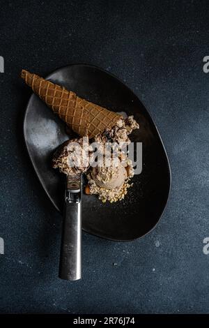 Des boules de café et de glace au chocolat sur fond de béton noir Banque D'Images