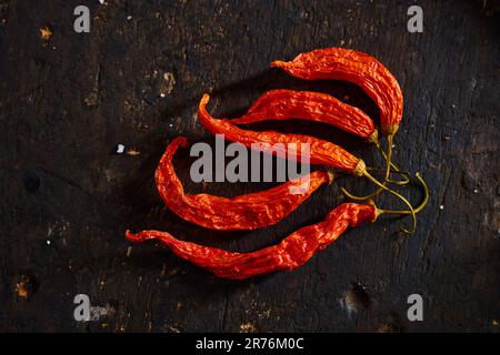 Vue de dessus des piments équatoriens longs rouge chaud et sec placés sur une table noire Banque D'Images