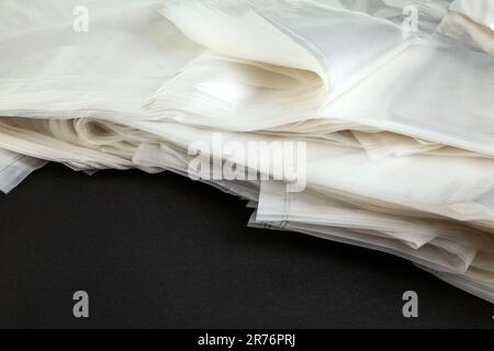 Pile de nouveaux sacs en plastique transparents avec poignées pour faire du shopping et transporter des objets. De nombreux sacs jetables en polyéthylène transparent Banque D'Images