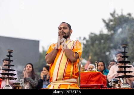 Varanasi, Inde - Nov 2022: Ganga aarti, Portrait d'un jeune prêtre exécutant la rivière ganges matin aarti à assi Ghat dans la robe traditionnelle. Banque D'Images