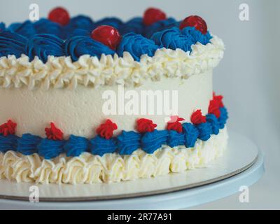 gâteau givré blanc bleu rouge isolé sur fond blanc de studio. Couleurs du drapeau américain. Célébration. Banque D'Images