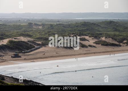Les surfeurs et les randonneurs apprécient la plage de Braunton Sands à North Devon, avec le système de dunes de Braunton Burrows et l'estuaire de la rivière Taw derrière eux. Banque D'Images