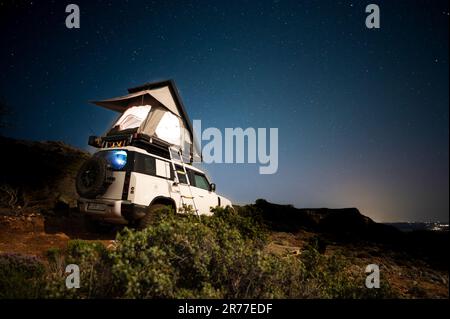 Camping romantique dans une tente sur le toit d'un 4x4 Offroad la nuit sous les étoiles Banque D'Images