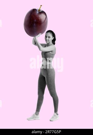 Jeune femme sportive avec prune fraîche sur fond de couleur Banque D'Images