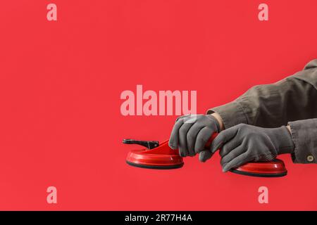 Les femmes ont les mains en gants et tiennent des ventouses à double aspiration sur fond rouge Banque D'Images