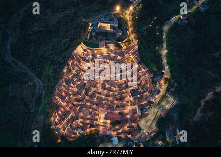 Vue aérienne de la ville italienne au sommet d'une colline, Rocca Imperiale au crépuscule dans la région de Calabre Banque D'Images