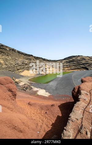 Une image de portrait d'un sentier sablonneux menant au lac verdoyant sur les plages d'El Golfo, Lanzarote. Banque D'Images