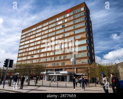 Les passagers passent par une place publique à l'extérieur de la gare de Swindon en Angleterre. Banque D'Images