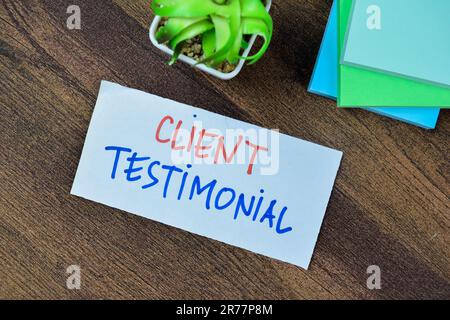 Concept du témoignage client écrire sur des notes adhésives isolées sur une table en bois. Banque D'Images