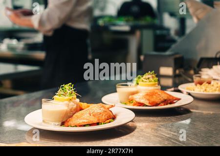 Commandes de nourriture sur la table de cuisine du restaurant, saumon grillé joliment décoré avec du riz et de la sauce blanche Banque D'Images