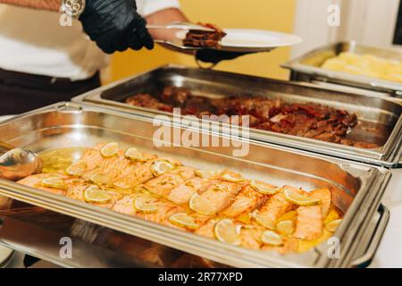Plat principal restauration pour mariage ou fête, serveur servant les invités Banque D'Images