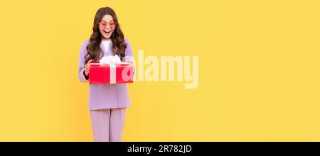 acheteur adolescent. élégante jeune fille dans la veste et les lunettes tiennent boîte cadeau. temps de shopping. Petite fille avec cadeau, affiche horizontale. En-tête de bannière avec co Banque D'Images